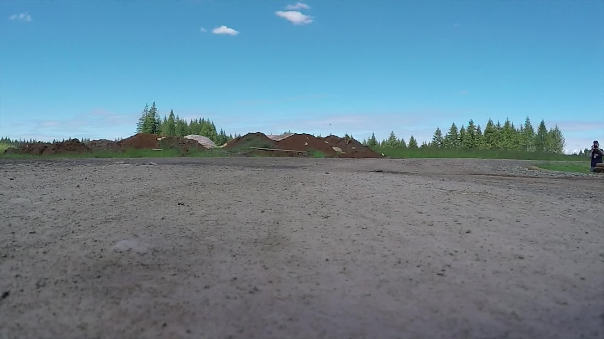 A quadcopter drone lifting off over a field during a training flight